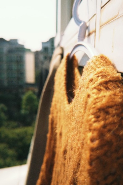 Sweater de lana color mostaza en una percha