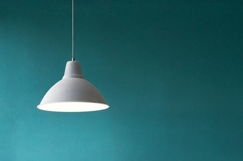 Lámpara colgante blanca sobre pared verde azulado