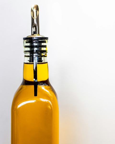 Botella de vidrio con aceite de oliva y pico vertedor