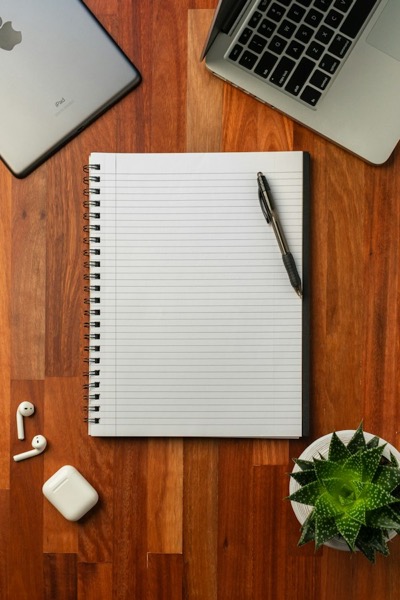 Cuaderno espiralado rayado con una lapicera sobre un escritorio