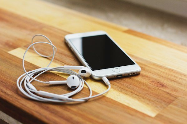 Celular con auriculares sobre una mesa de madera